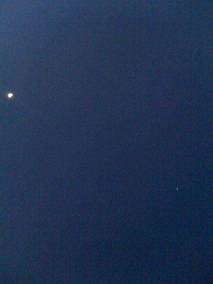 The moon and the space station in the night sky